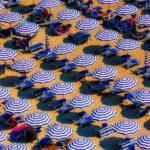 aerial view of blue and white open cottages at the beach