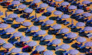 aerial view of blue and white open cottages at the beach