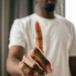 black man with index finger pointing up